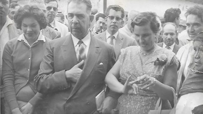 El General Lázaro Cárdenas del Río, en Ciudad Hidalgo, Mich. (6 de abril de 1959) después de beber agua (envenenada) y acompañado de la Comisión -en la que había tres mujeres- integrada por gente del pueblo, para luchar por la libertad de los presos en Morelia, acusados de matar al cacique Aquiles de la Peña. A su izquierda Margarita Marín Acosta (madre de Nidia Marín).